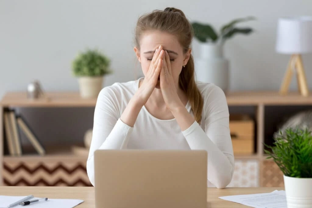 Young woman experiencing anxiety and emotional stress while sitting in front of a laptop, representing professional anxiety management and psychological counseling services in Lahore.