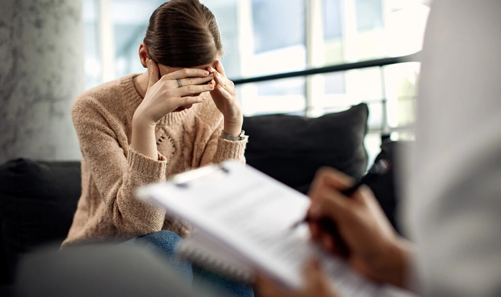 A professional psychologist providing depression management counseling to an adult client during a confidential mental health therapy session in Lahore.