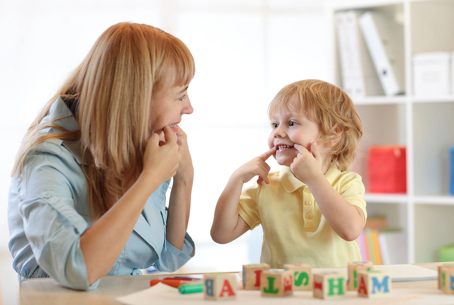 Speech therapist helping a young child improve speech, pronunciation, language development, and communication skills during a personalized speech therapy session in Lahore.